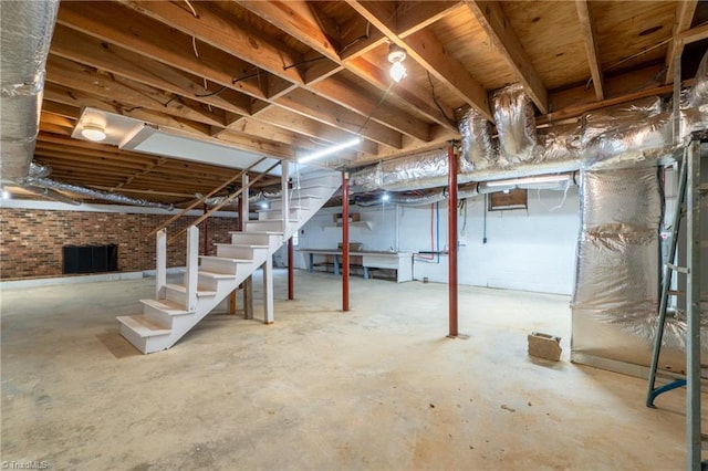 basement featuring heating unit and brick wall