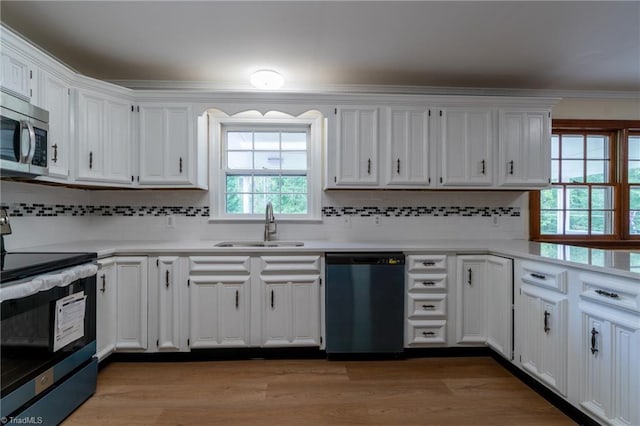 kitchen with stainless steel appliances, light hardwood / wood-style floors, decorative backsplash, and white cabinetry