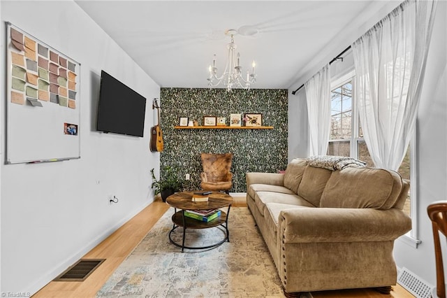 living area with hardwood / wood-style floors and a notable chandelier