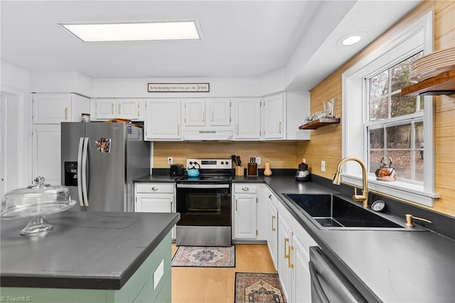 kitchen with tasteful backsplash, appliances with stainless steel finishes, sink, and white cabinetry