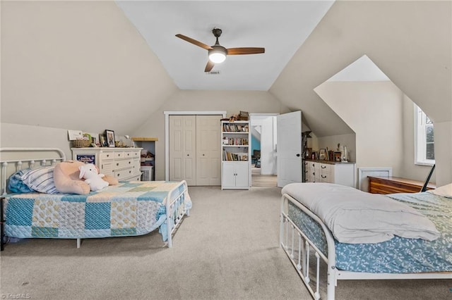 carpeted bedroom with vaulted ceiling, a closet, and ceiling fan