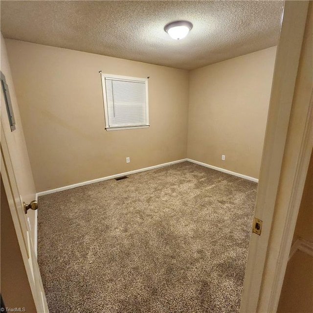 carpeted empty room with a textured ceiling