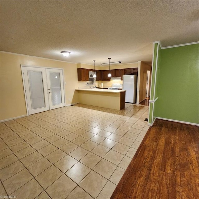 kitchen with light wood-type flooring, white refrigerator, a textured ceiling, pendant lighting, and kitchen peninsula