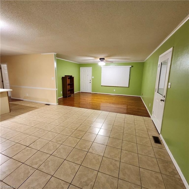 unfurnished room with ornamental molding, ceiling fan, a textured ceiling, and light hardwood / wood-style floors