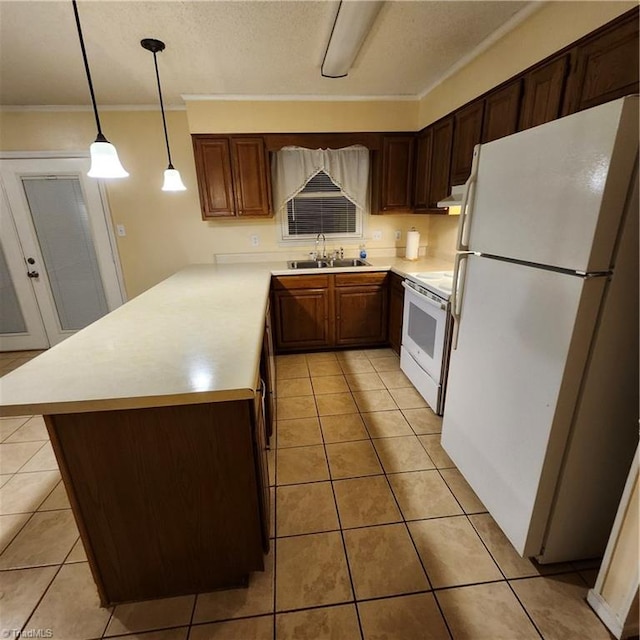 kitchen with pendant lighting, white appliances, sink, and light tile patterned floors