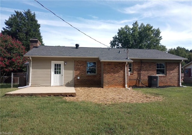 rear view of house with cooling unit, a lawn, and a patio