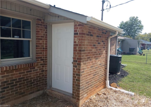 doorway to property featuring a lawn and central AC