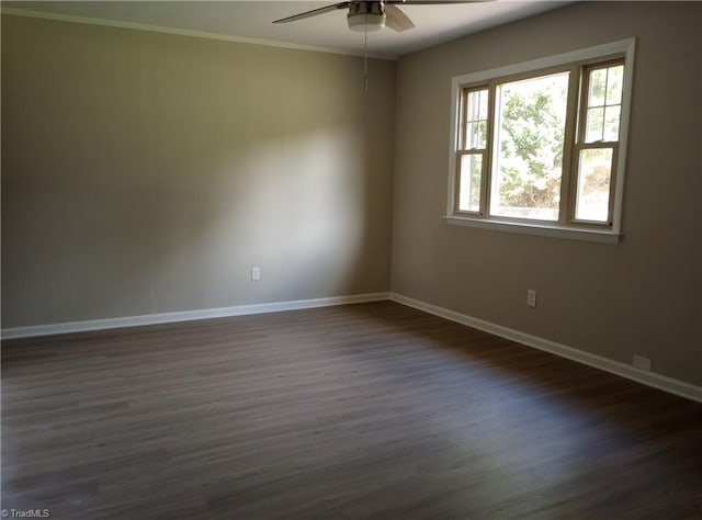 empty room with ceiling fan, dark wood-type flooring, and crown molding