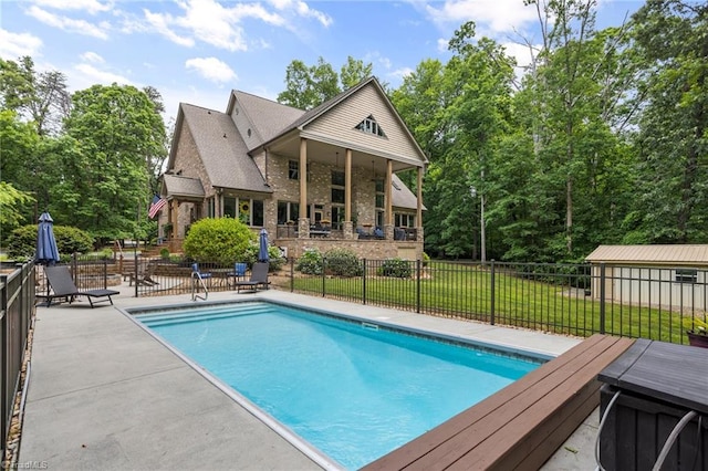 view of swimming pool with a yard and an outdoor structure