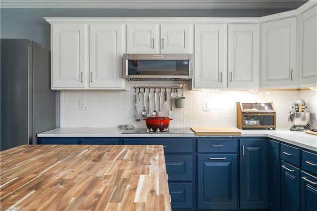 kitchen featuring butcher block countertops, white cabinetry, appliances with stainless steel finishes, and blue cabinets