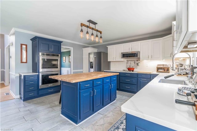 kitchen featuring blue cabinets, wood counters, a kitchen island, and appliances with stainless steel finishes