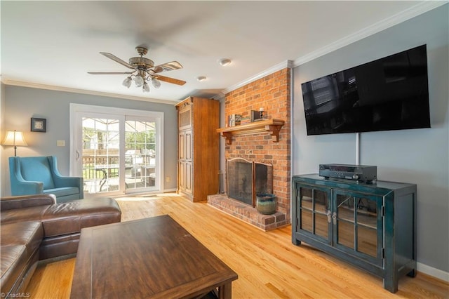 living room with crown molding, light wood-style flooring, and a fireplace