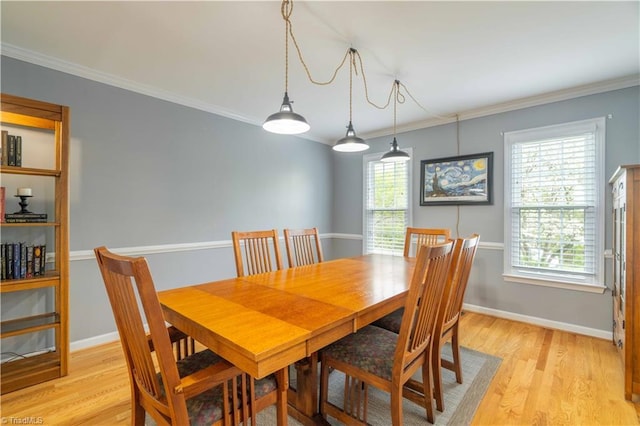 dining space with baseboards, light wood-style floors, and ornamental molding