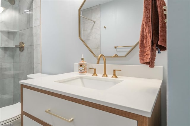 full bathroom with a tile shower, toilet, and vanity