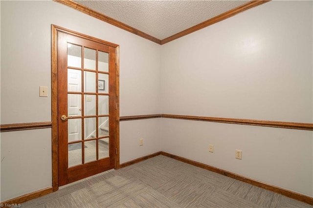 spare room with light carpet, baseboards, a textured ceiling, and crown molding