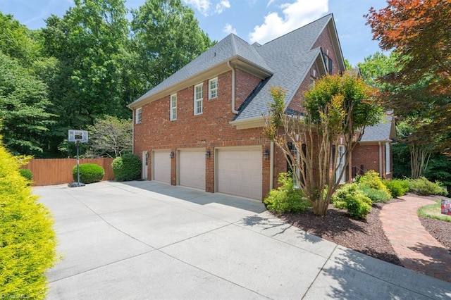 5000 Casting Way, Greensboro, NC 27455 - view of side of home featuring an attached garage, brick siding, roof with shingles, and driveway