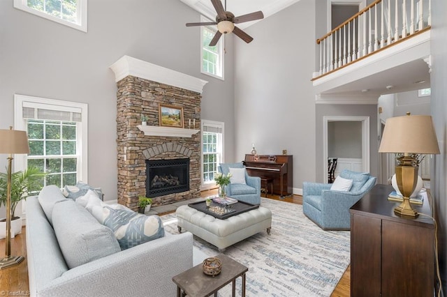 5000 Casting Way, Greensboro, NC 27455 - living room featuring a high ceiling, ceiling fan, healthy amount of natural light, wood finished floors, and a stone fireplace