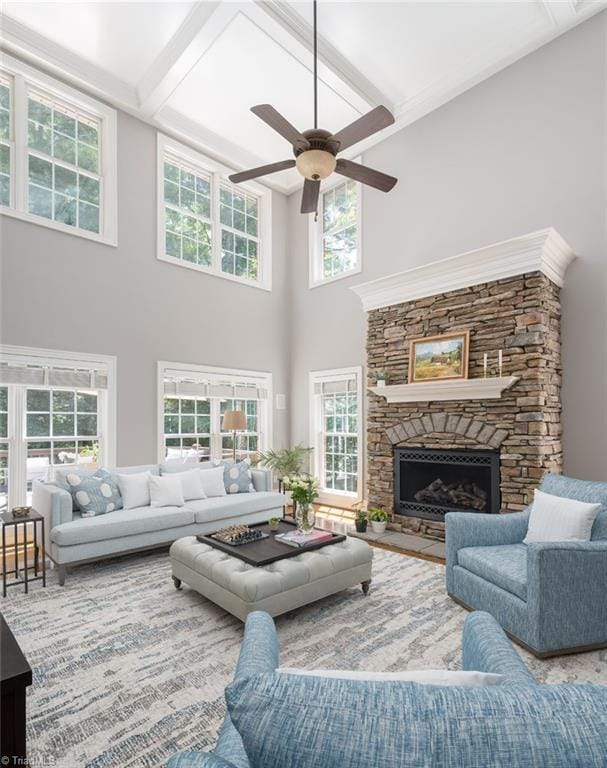 5000 Casting Way, Greensboro, NC 27455 - living room featuring a ceiling fan, a high ceiling, plenty of natural light, a stone fireplace, and beam ceiling