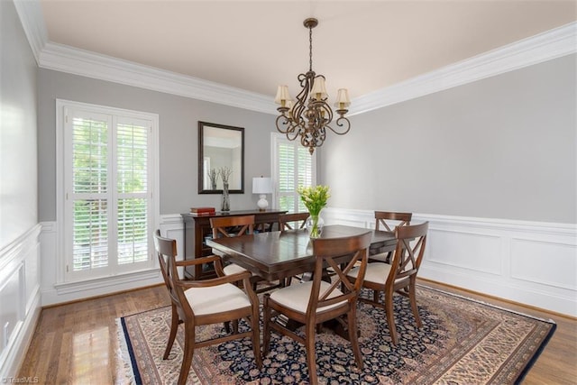 5000 Casting Way, Greensboro, NC 27455 - dining room featuring ornamental molding, a chandelier, a wainscoted wall, wood finished floors, and a decorative wall