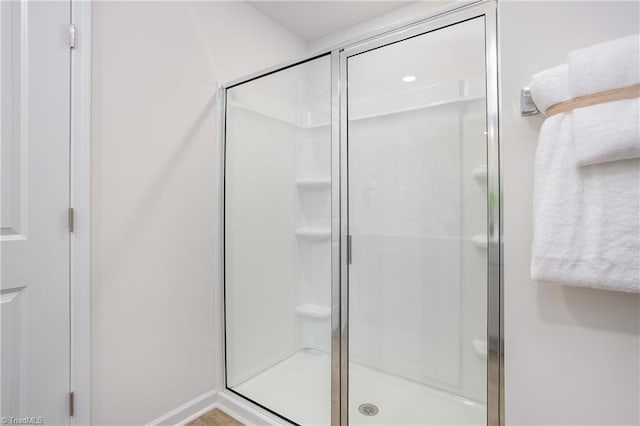 bathroom featuring a shower with door