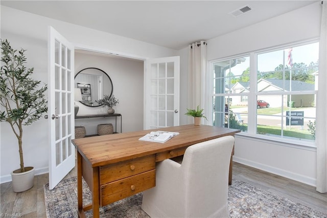 home office with french doors and hardwood / wood-style floors