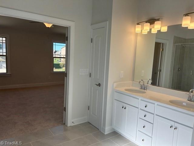 bathroom featuring vanity, tile patterned floors, and a shower with shower door