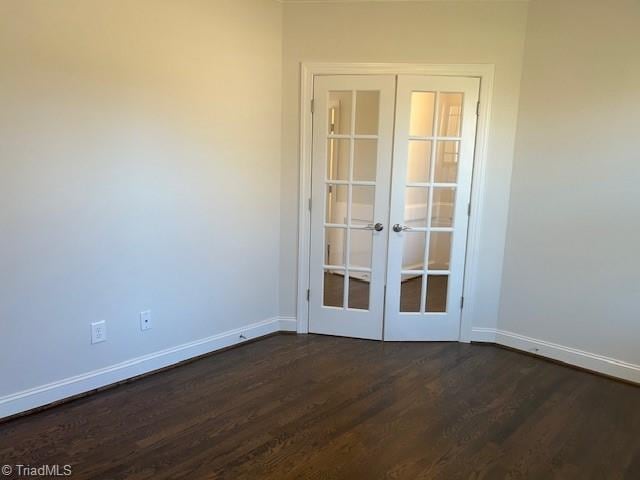 spare room with french doors and dark hardwood / wood-style floors