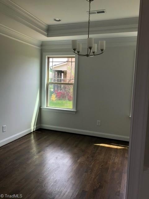 unfurnished dining area with dark wood-type flooring, crown molding, and an inviting chandelier