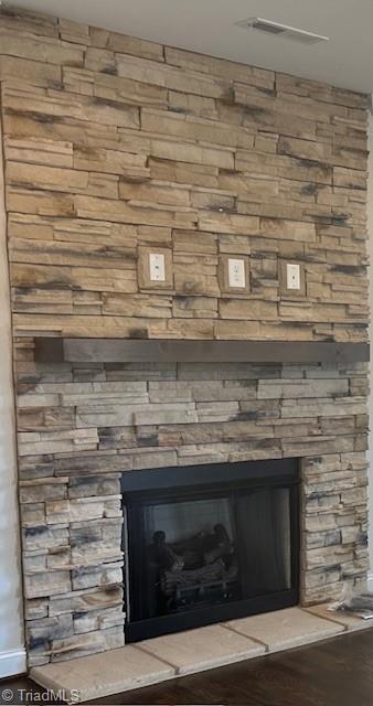 room details featuring a stone fireplace and hardwood / wood-style floors