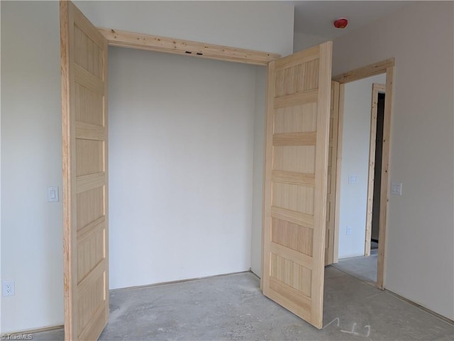 empty room with unfinished concrete flooring