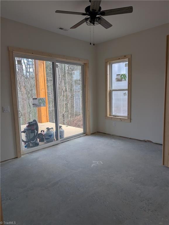 empty room with concrete floors, plenty of natural light, and visible vents