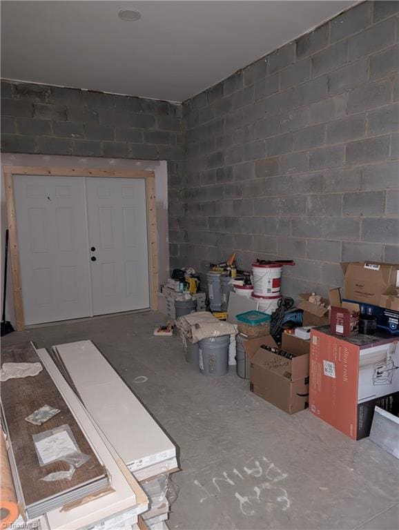 interior space featuring concrete block wall and concrete floors