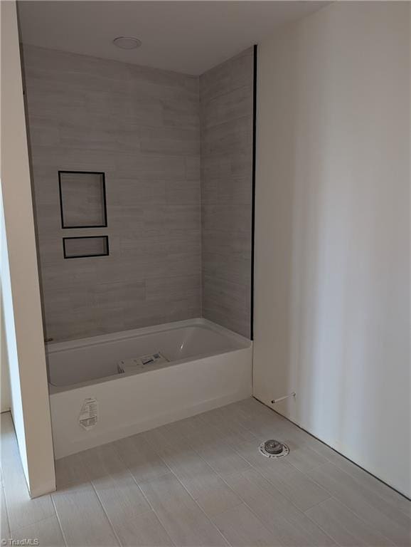 full bath featuring washtub / shower combination and tile patterned floors