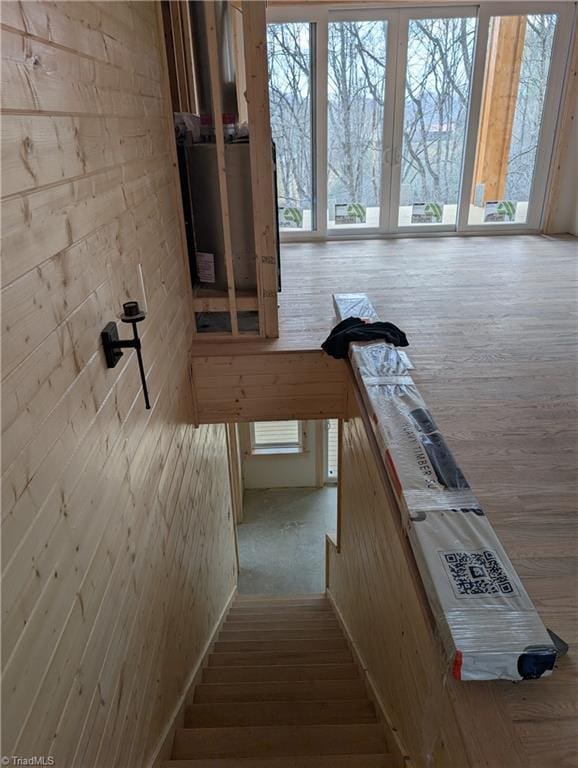 stairs featuring wooden walls and wood finished floors