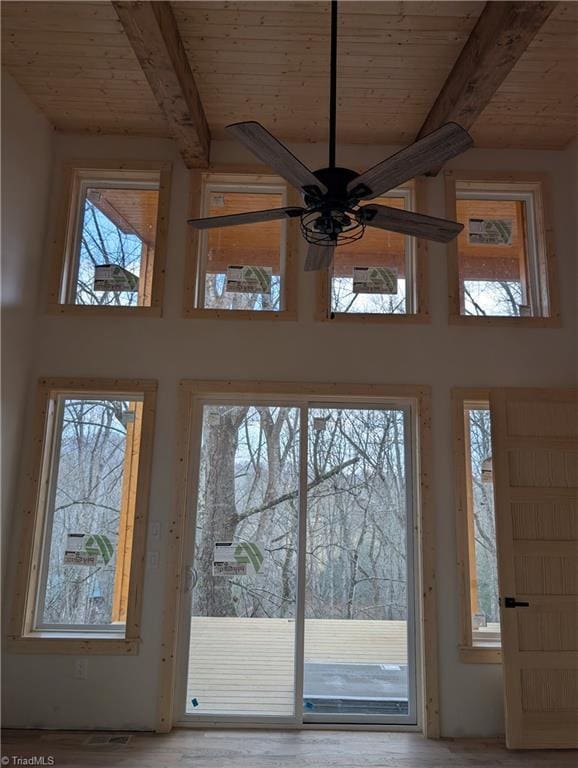 doorway to outside with beam ceiling, wooden ceiling, ceiling fan, and a towering ceiling