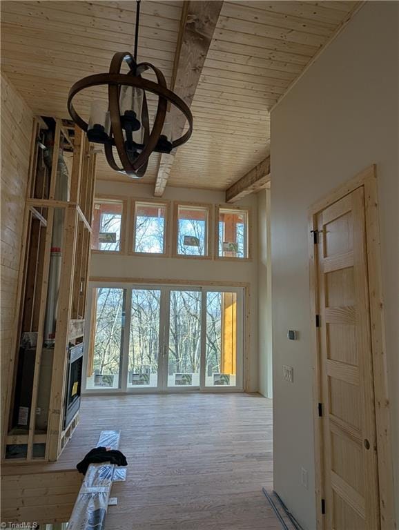 workout area featuring wooden ceiling, a high ceiling, and wood finished floors