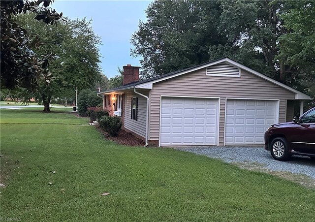 702 Trail One, Burlington, NC 27215 - view of property exterior featuring a chimney, a detached garage, and a yard