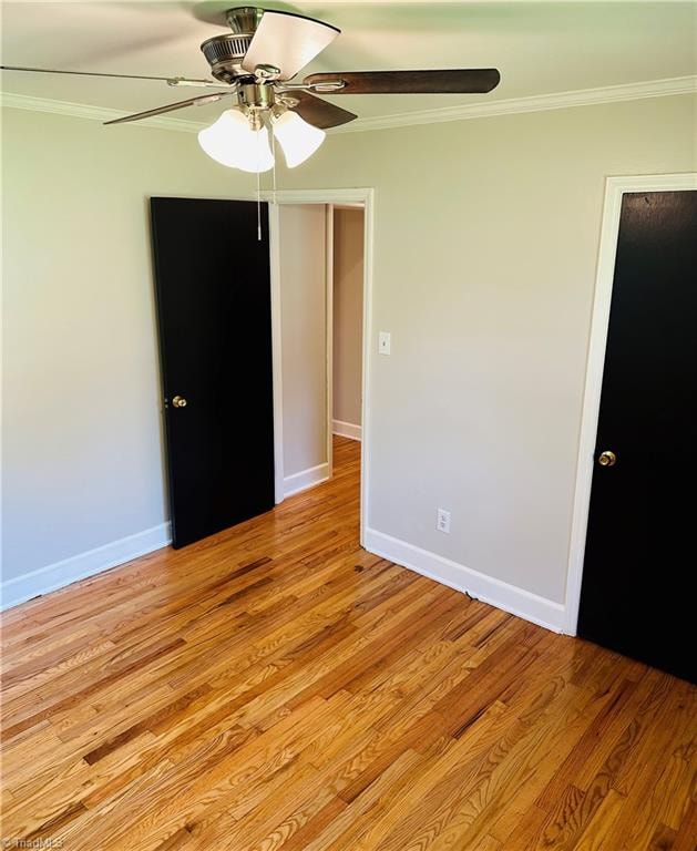 unfurnished bedroom with ceiling fan, light wood-type flooring, a closet, and crown molding