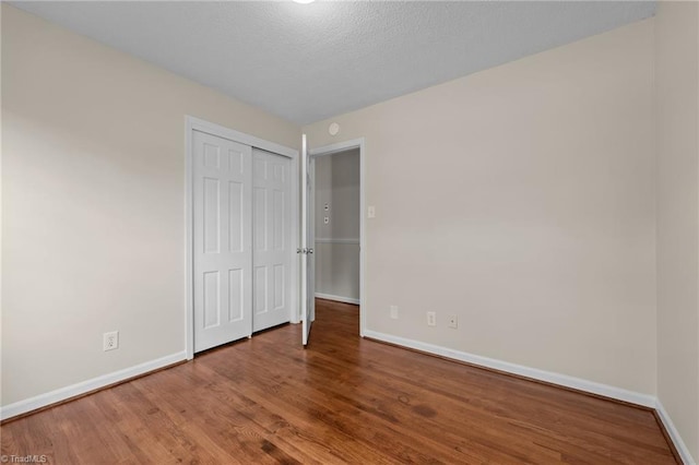 2206 Revolan Dr, Greensboro, NC 27407 - unfurnished bedroom with wood finished floors and a closet