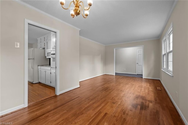 2206 Revolan Dr, Greensboro, NC 27407 - unfurnished room with a chandelier, wood finished floors, and crown molding