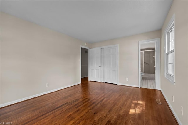 2206 Revolan Dr, Greensboro, NC 27407 - unfurnished bedroom with wood finished floors, a closet, and ensuite bath