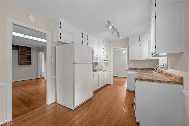 2206 Revolan Dr, Greensboro, NC 27407 - kitchen with white appliances, light wood-type flooring, and white cabinetry