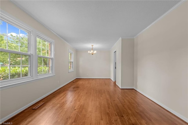 2206 Revolan Dr, Greensboro, NC 27407 - spare room featuring a chandelier, light wood-style flooring, and ornamental molding