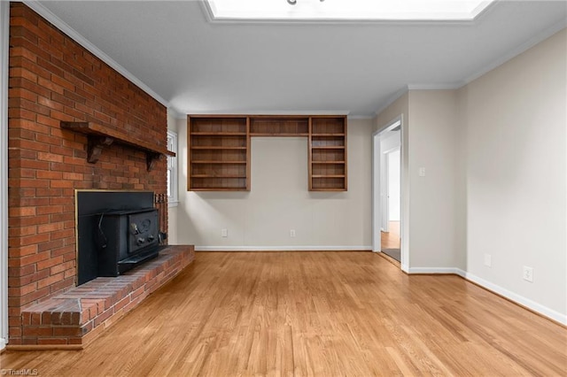 2206 Revolan Dr, Greensboro, NC 27407 - unfurnished living room featuring a wood stove, light wood-style flooring, ornamental molding, and healthy amount of natural light