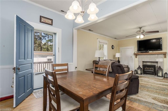 4724 Old Julian Rd, Julian, NC 27283 - dining space featuring light wood-type flooring, crown molding, a chandelier, ceiling fan, and wainscoting