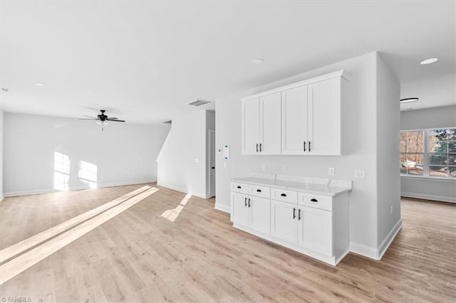 kitchen featuring ceiling fan, light hardwood / wood-style floors, and white cabinetry