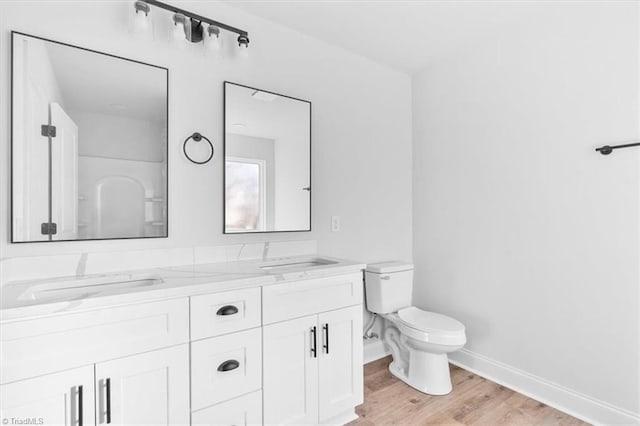 bathroom with hardwood / wood-style floors, vanity, and toilet