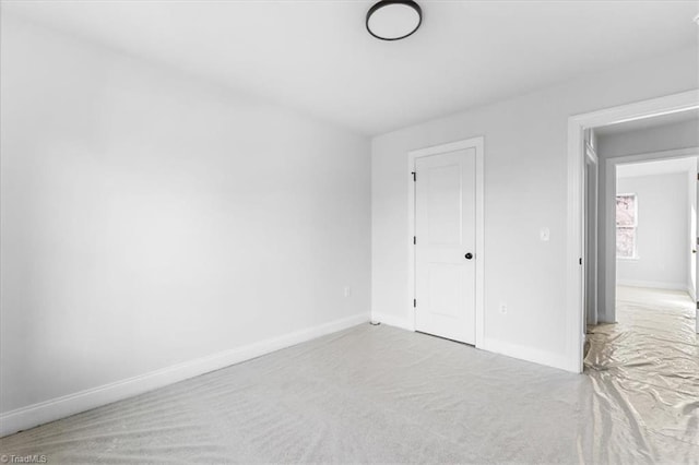 unfurnished bedroom featuring a closet and light carpet