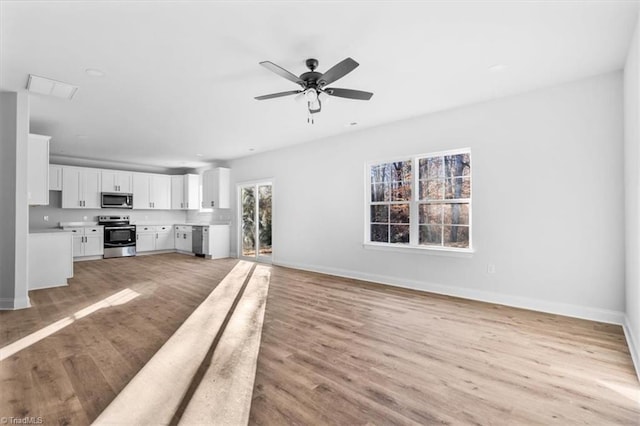 unfurnished living room featuring ceiling fan and light hardwood / wood-style flooring