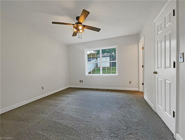 unfurnished bedroom with a textured ceiling, dark colored carpet, and ceiling fan